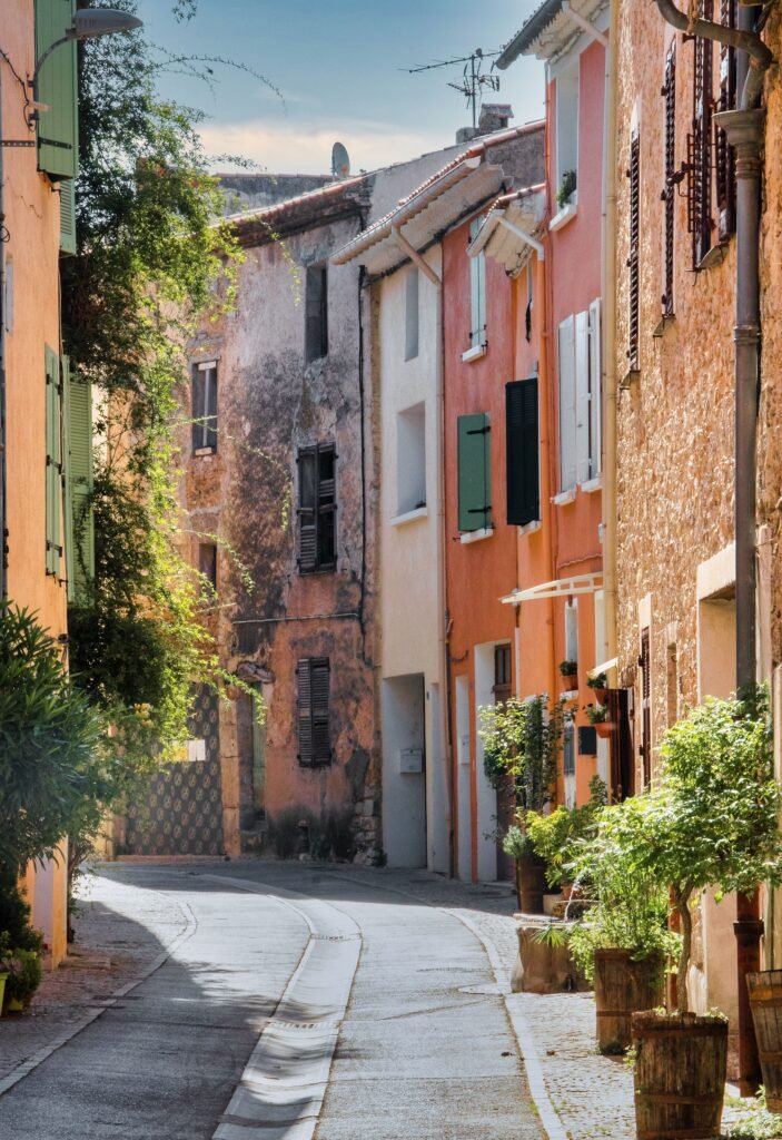Scenic view of a narrow cobblestone street lined with colorful townhouses in a European town.