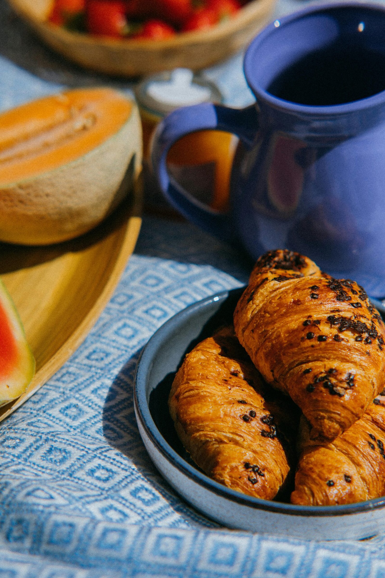 GÎTE ET CHAMBRE Delicious breakfast setup with fresh croissants and fruits. Perfect for a cozy morning meal.